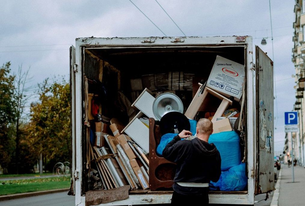 a man unloading furniture from the back of a moving truck